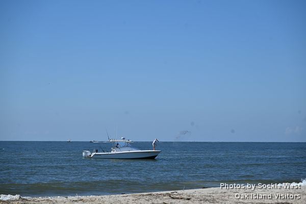 A fishing boat just off the beach on a calm day